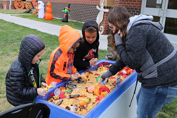 Blackmore students exploring a sensory table with corn and fall themed objects