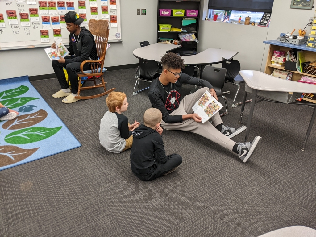 basketball players reading to first graders