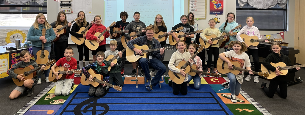 Grandview fifth grade students with guitars and Cooper Crawford